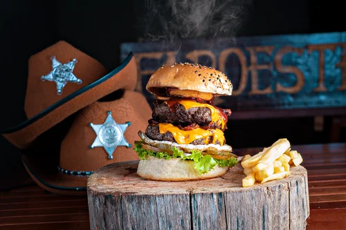 Hambúrguer duplo artesanal com dobro de cheddar derretido, ovo na chapa e onion rings